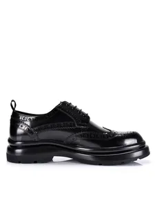 Seitenansicht schwarzer Herren-Brogues aus Leder mit dicker Sohle und Schnürung