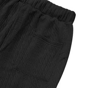 Close-up of black cable-knit texture and pocket detail on men's jogger pants