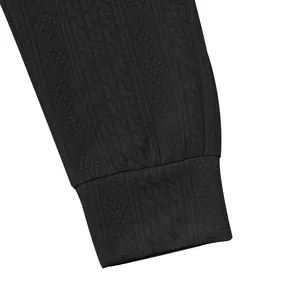 Close-up of black textured knit fabric and ribbed cuff on high-quality men's jogger pants