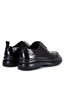 Detailansicht der schwarzen Brogue-Schuhe für Herren mit feiner Flügelkappen-Stanzung.
