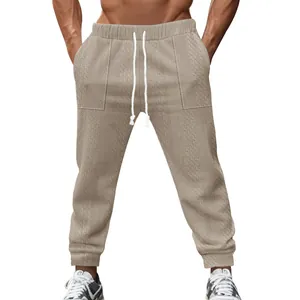 Detail view of men's knitted jogger pants with textured pattern and drawstring