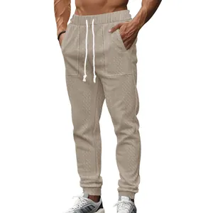 Macro detail of men's knit joggers showing textured cable pattern and drawstring waist