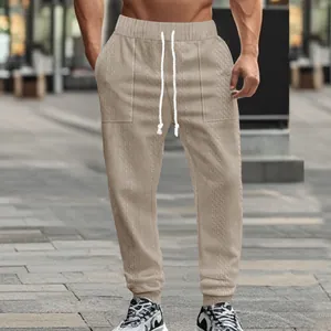 High-quality detailed view of men's beige knit joggers featuring a textured drawstring waist