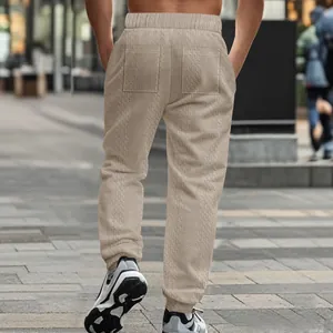 Back detail of men's knitted joggers showing textured pattern and rear pockets.