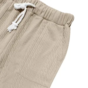 Detailed macro shot of khaki knitted jacquard texture and white drawstring on men's casual pants