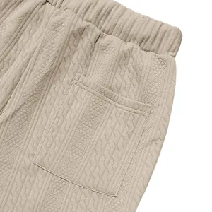 Close-up of beige men's knitted pants showing vertical textured patterns and pocket detail