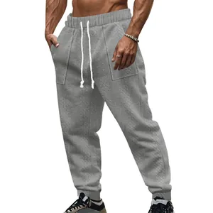 Detailed view of men's breathable gray knitted drawstring joggers with textured pattern