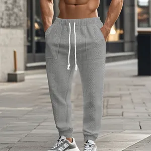 Close-up detail of men's grey cable-knit joggers featuring a functional drawstring waist