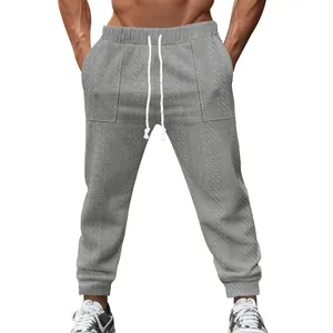 Detailed view of grey cable knit men's joggers with white drawstring waist