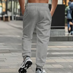 Back view of men's grey knit jacquard jogger pants in an urban street setting