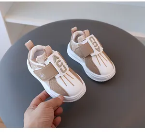 Nahaufnahme stilvoller Kinder-Sneaker in Khaki und Weiß mit praktischem Klettverschluss