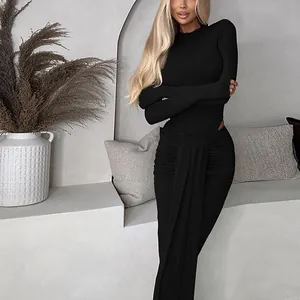 Nahaufnahme von elegantem schwarzem Body mit gerafftem Schlitzrock an Model in Minimalistik