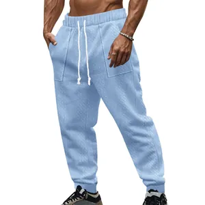 Close-up of light blue men's knit sweatpants with white drawstring and texture
