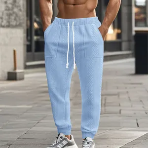 Close-up of men's light blue knitted joggers featuring textured pattern and drawstring waist