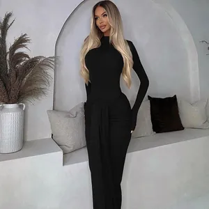 Detail des eleganten schwarzen Langarm-Bodysuits kombiniert mit einem gerafften Schlitzrock.