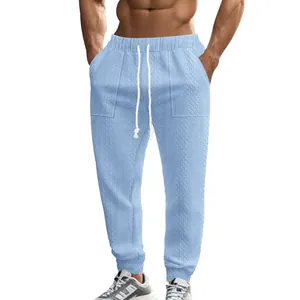 Detail of men's blue knitted joggers with drawstring and textured pattern