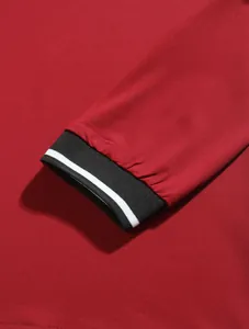 Detailed close-up showing the black striped rib-knit cuff of a red long-sleeve men's Polo shirt