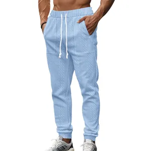 Detailed view of light blue knitted men's joggers with drawstring and textured pattern