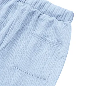 Detail showing the pocket and knitted jacquard texture of men's casual trousers.