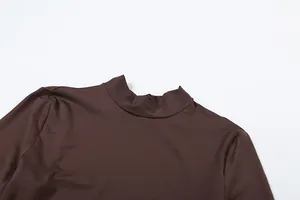 Nahaufnahme des Stehkragens eines braunen, langärmeligen Bodysuits aus elastischem Stoff