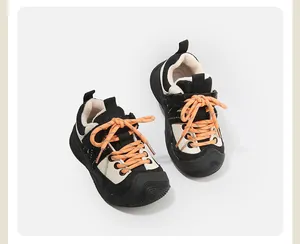 Vue détaillée de baskets noires et blanches pour enfants avec doublure polaire et lacets orange.