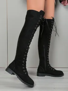 Vue détaillée de bottes au-dessus du genou en daim noir avec lacets et semelle crantée