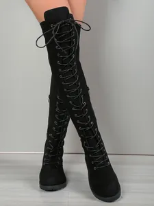 Vue détaillée des bottes au-dessus du genou en daim noir avec laçage élégant à l'avant