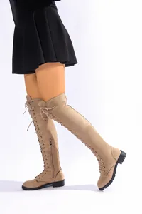 Vue détaillée de bottes cuissardes en daim beige avec lacets et fermeture éclair latérale