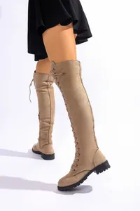 Vue détaillée des bottes au-dessus du genou en daim beige avec lacets et talon.