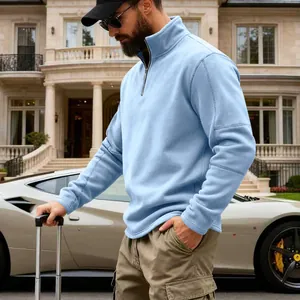 Detalle de hombre con sudadera de forro polar azul claro en un entorno de lujo