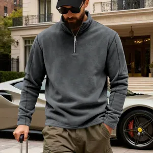Detalle de hombre con sudadera de forro polar gris con media cremallera en ambiente de lujo