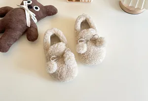 Macro view showing the soft texture of children's fleece slippers with pompoms and bows