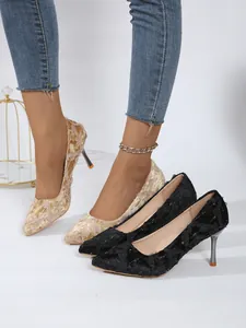 Close-up of elegant pointed-toe stiletto heels with delicate floral lace applique detail
