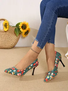 Detailed view of green pointed-toe high heels featuring a festive Christmas holiday print.