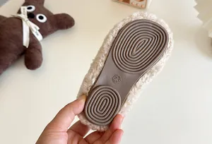 Detailed macro view of non-slip rubber sole for children's plush warm slip-on shoes.