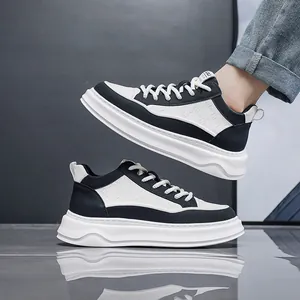 Modische Herren-Sneaker mit dicker Sohle in Schwarz-Weiß auf einer reflektierenden Fläche