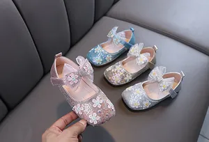 Détail des chaussures de princesse pailletées pour filles avec fleurs et nœuds papillon