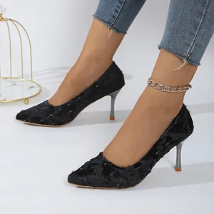 Elegant black pointed-toe stiletto pumps with lace texture on model