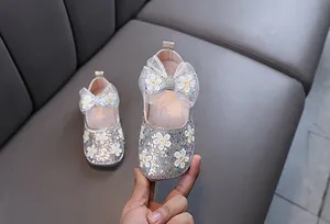 Détail de chaussures princesse fille argentées scintillantes avec broderie fleur