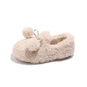 Cozy cream fleece children's slip-on shoes featuring cute pom-poms and a decorative bow.