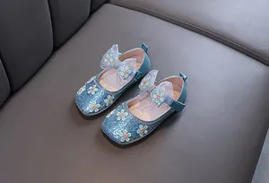 Gros plan de ballerines princesse bleues à paillettes avec nœud en tulle et broderie fleurie