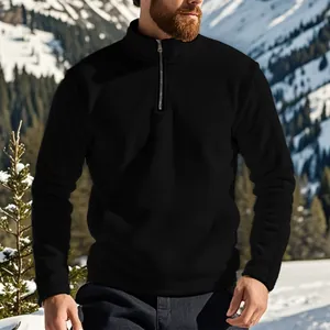 Detailopname van een zwarte heren fleece sweater met halve rits in een berglandschap
