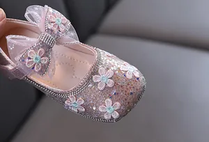 Gros plan de chaussures de princesse roses pailletées avec fleurs et nœud en dentelle