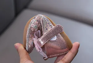 Détail de chaussures de princesse roses à strass montrant la souplesse de la semelle