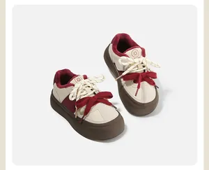 Detail van stijlvolle kinderschoenen met bordeauxrode veters en pluche voering