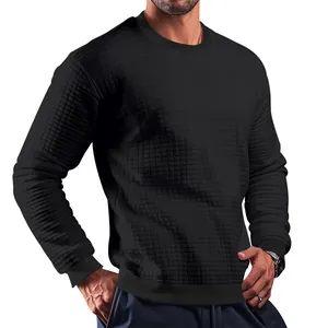 Detailed view of black crew neck knit sweater with small grid texture for men.