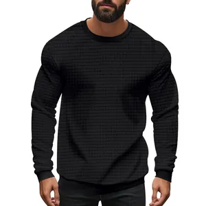 Detailed macro view of the black textured small checkered fabric on men's knit sweater.