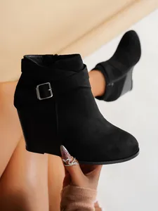 Vue détaillée de bottines à talon compensé en daim noir avec boucle décorative et zip latéral