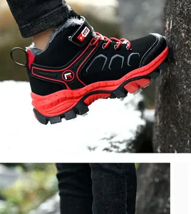 Detail of kids winter hiking boots with warm fleece lining and non-slip red sole in snow