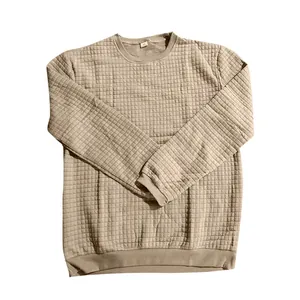 Detail of khaki men's slim fit knit sweater with small grid texture and round neck design.